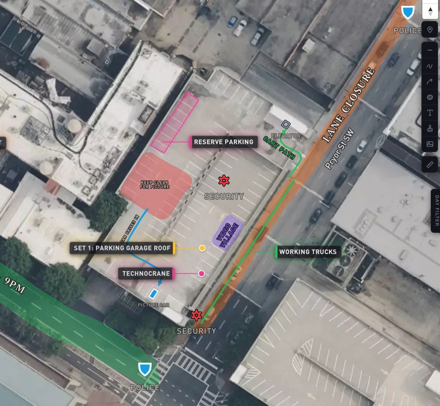 A set drawn on by hand — a lane closure marked along the street, a cart path, a keep-clear-for-picture area, security stamps and a rotated video village label.