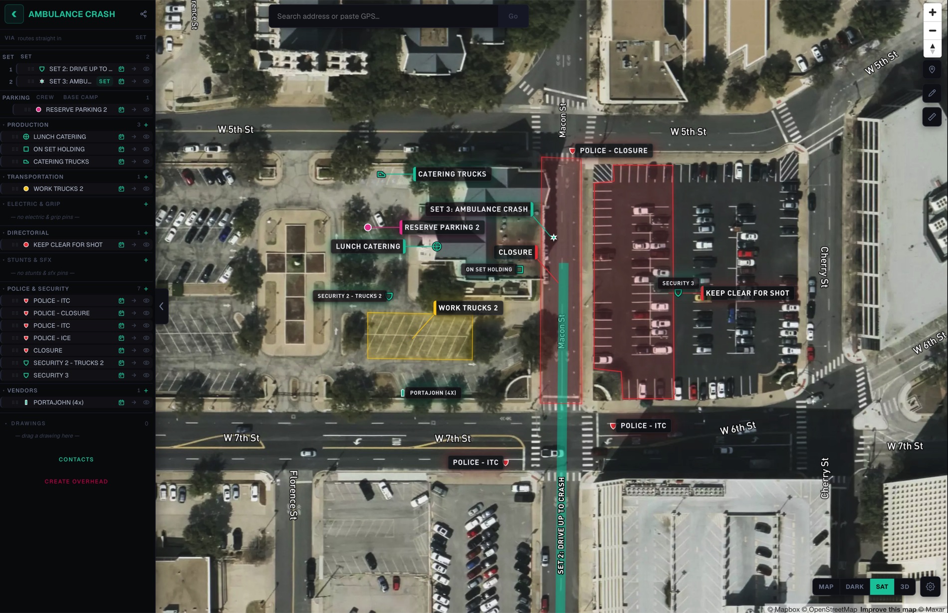 A set open on satellite imagery — department layers down the left, labelled pins across the map, a police closure zone and a work-truck area marked out.